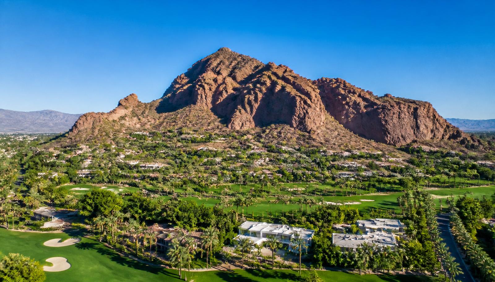 Camelback Mountain at golden hour in Scottsdale, Arizona, with a saguaro cactus silhouetted against the warm desert sky