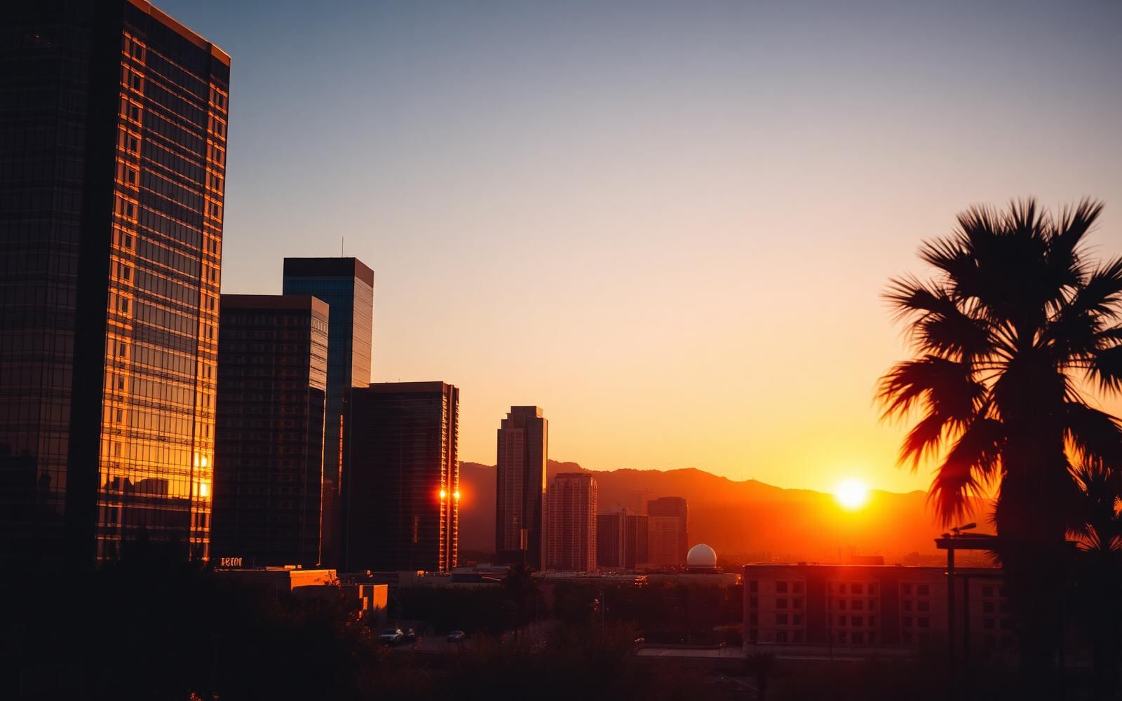 Downtown Phoenix, Arizona skyline glowing at warm sunset with desert mountains in the background